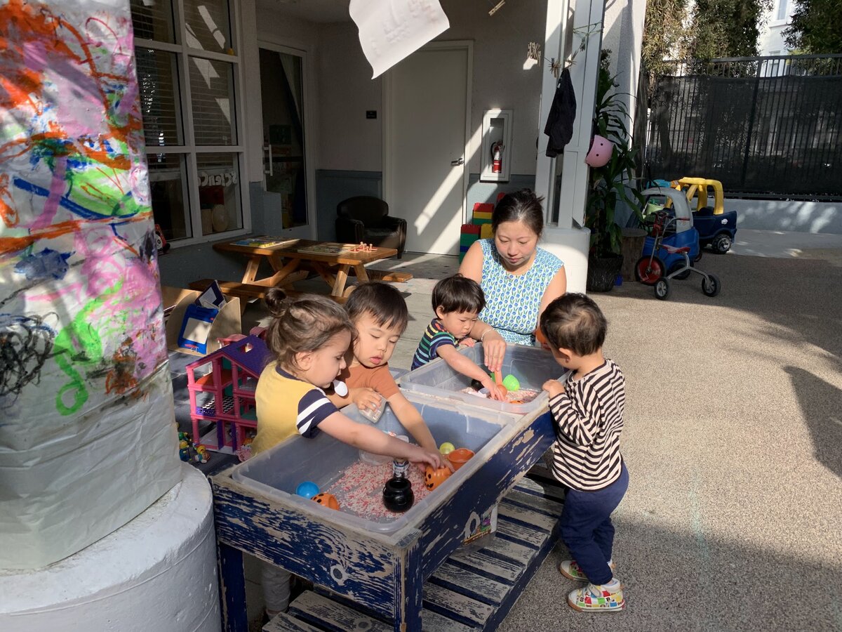 Children exploring the outdoor sensory water table in the Kangaroo Room