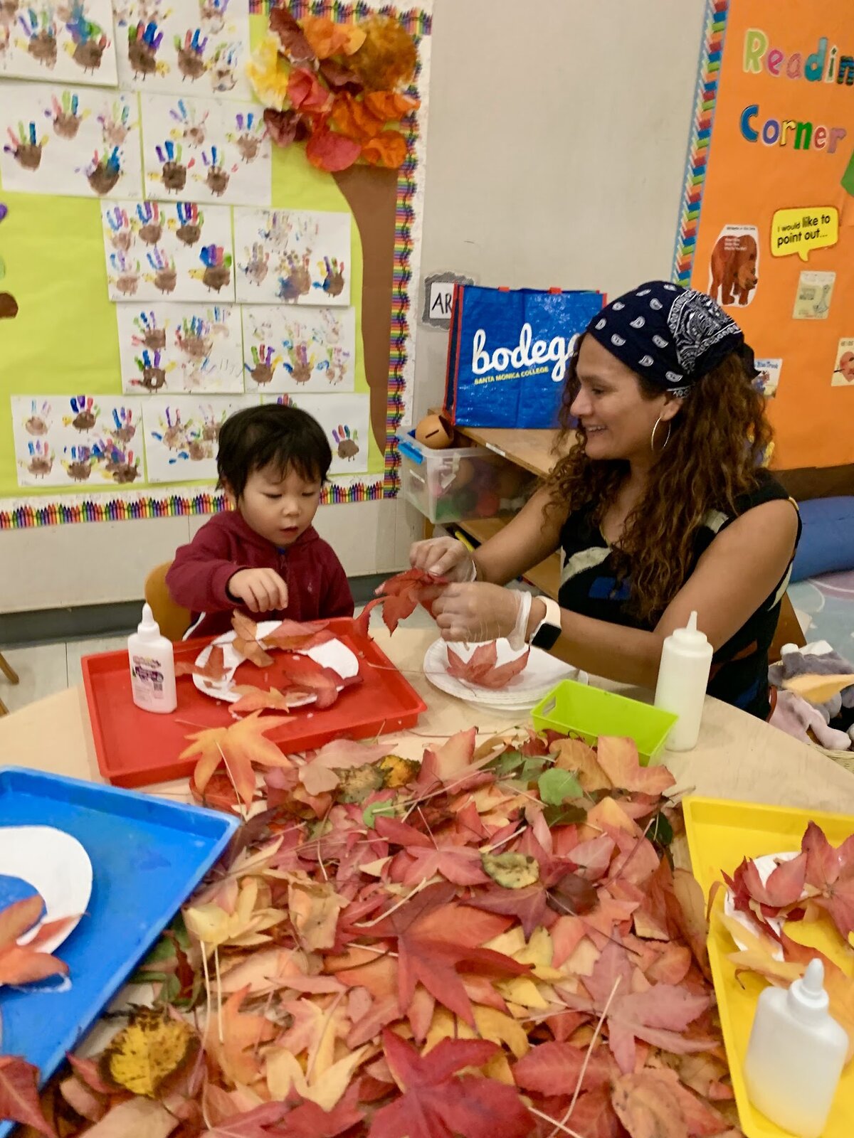 Toddlers exploring leaves and nature outdoors in the Kitten Room